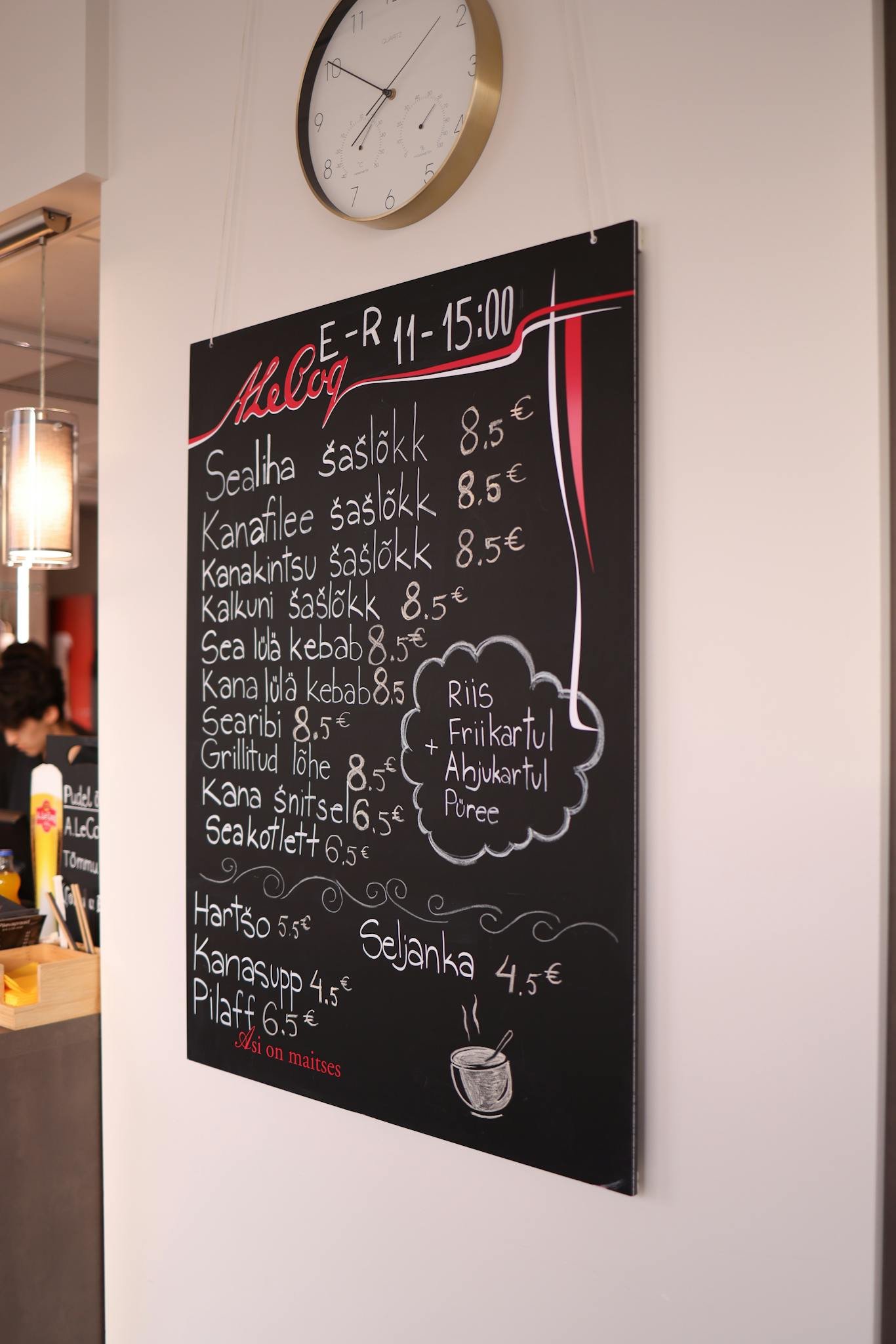 Chalkboard menu in a cafe with prices, highlighting a modern indoor ambiance.